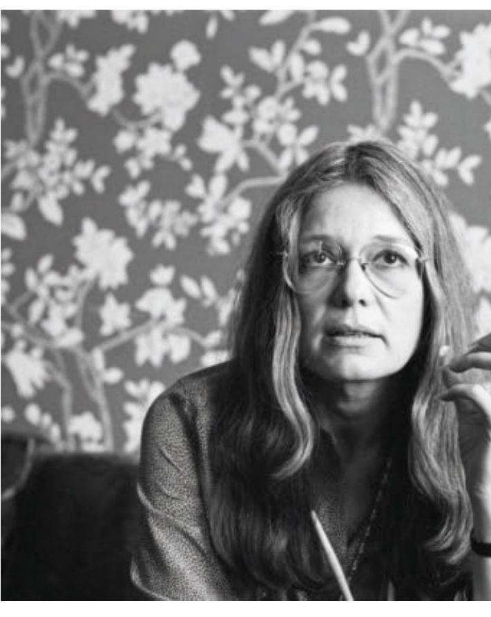 Portrait de Gloria Steinem, cheveux longs et lunettes d'aviateur.